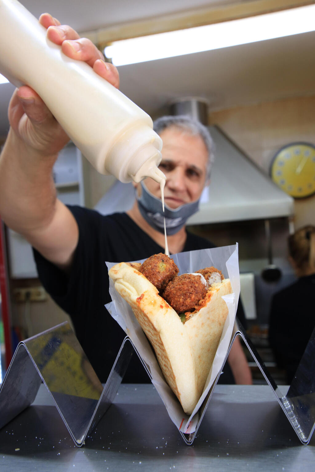 הכנת מנת פלאפל בפיתה בפלאפל יד אליהו